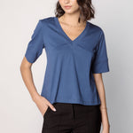 Polera Cassie de la marca EI-2025-501, blusa de manga larga en color gris claro con detalles en el cuello y puños.