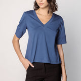 Polera Cassie de la marca EI-2025-501, blusa de manga larga en color gris claro con detalles en el cuello y puños.