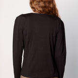 Polera Zinnia de la marca O-2025-504 en color sólida, con cuello redondo y manga larga, mostrada en la imagen.
