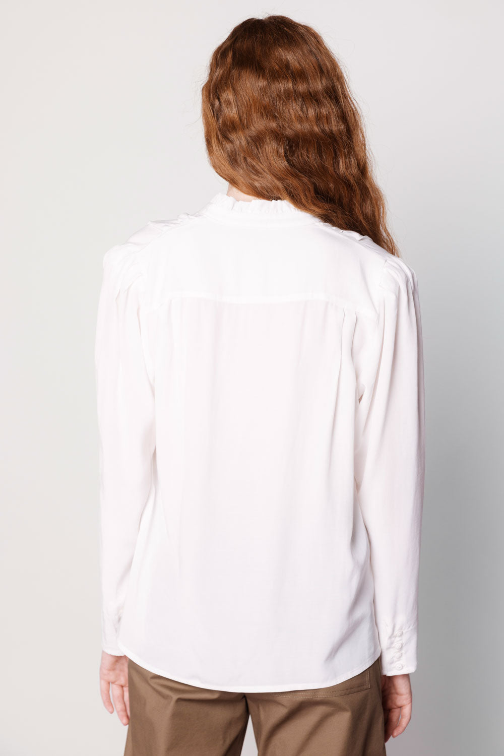 Blusa Kunai de la marca O-2025-611, con diseño moderno y detalles en la tela, en color neutro sobre fondo blanco.