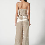 Pantalón Adela de la marca FV-2025-804, pantalones de tela en color oscuro, mostrados colgados en un perchero.