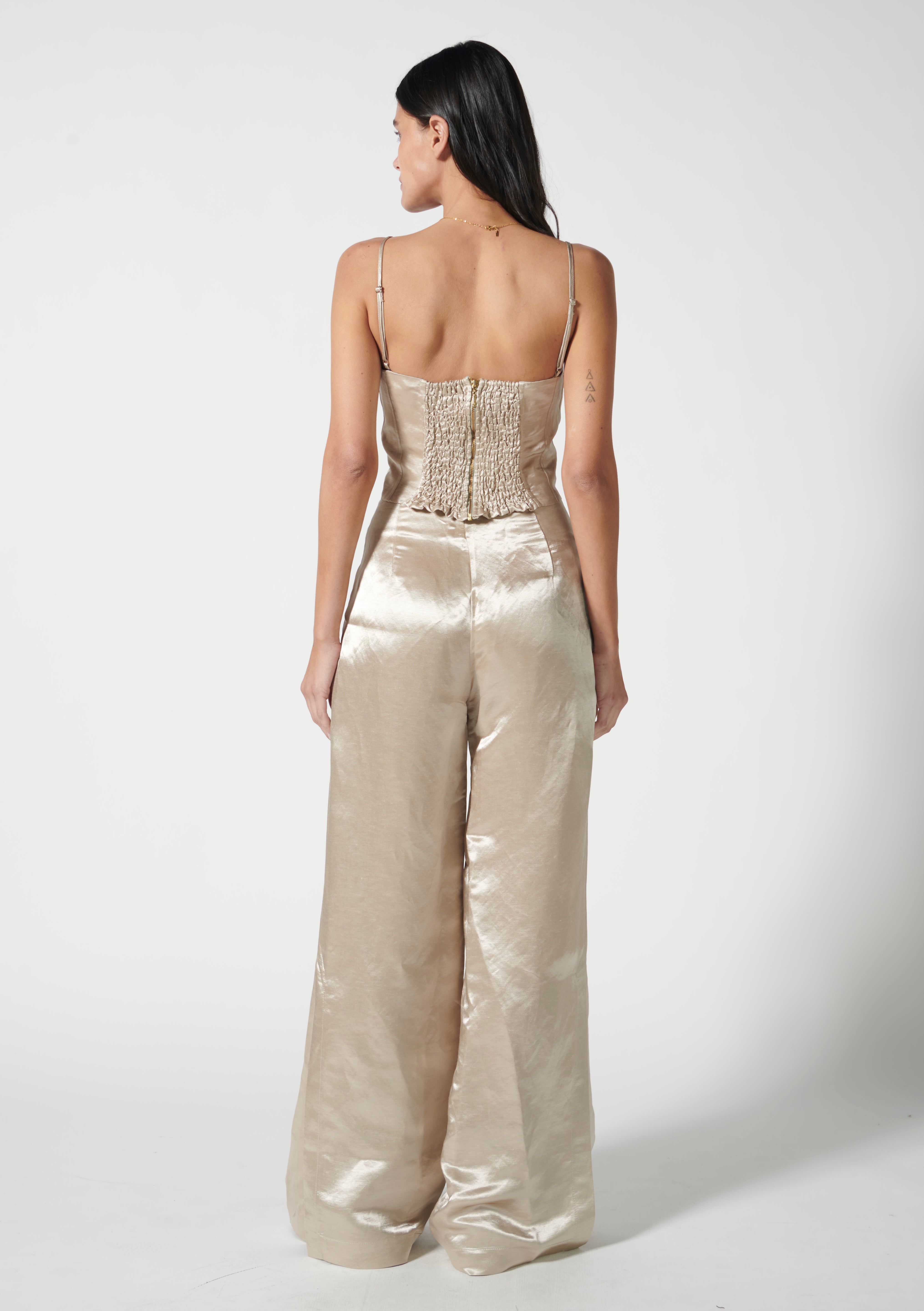 Pantalón Adela de la marca FV-2025-804, pantalones de tela en color oscuro, mostrados colgados en un perchero.