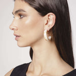 Aros Elsie en color dorado, accesorios elegantes de la marca BI-2024-236, con diseño moderno y brillante.
