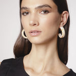 Aros Elsie en color dorado, accesorios elegantes de la marca BI-2024-236, con diseño moderno y brillante.