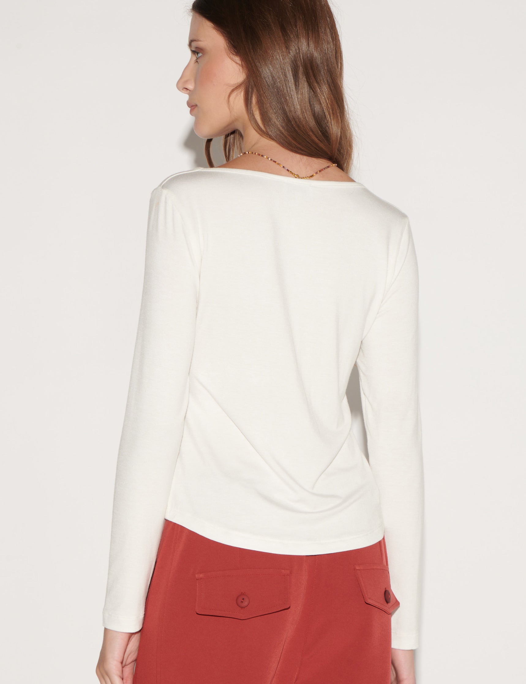 Polera blanca Lucia de la marca EI-2026-501, blusa de manga larga y corte simple, visible en la imagen.