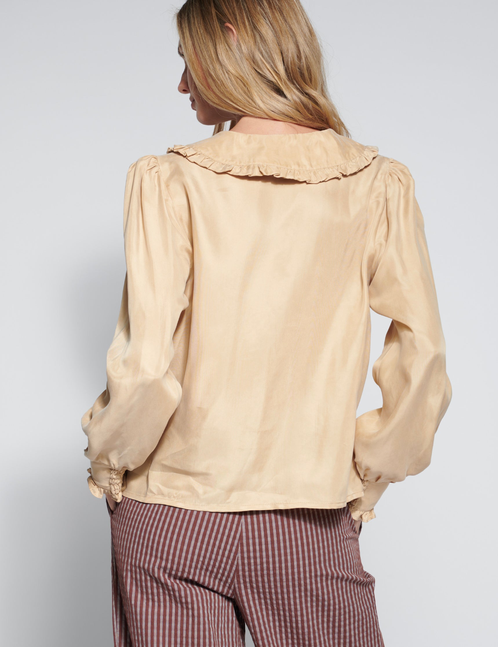 Blusa Rêverie Arena de la marca EI-2026-604, en color neutro, con diseño elegante y mangas largas sobre fondo blanco.