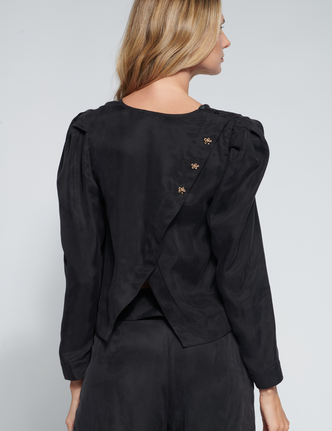 Blusa negra FI-2026-600 de la colección Roda Black, de manga larga y corte ajustado, en un fondo neutro.