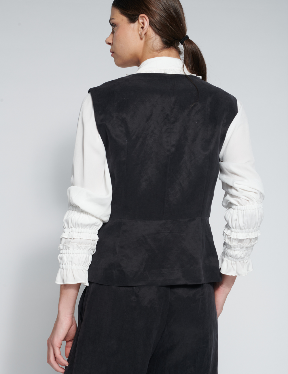 Chaleco Zini negro de tejidos, estilo moderno y elegante, con detalles en la parte frontal.