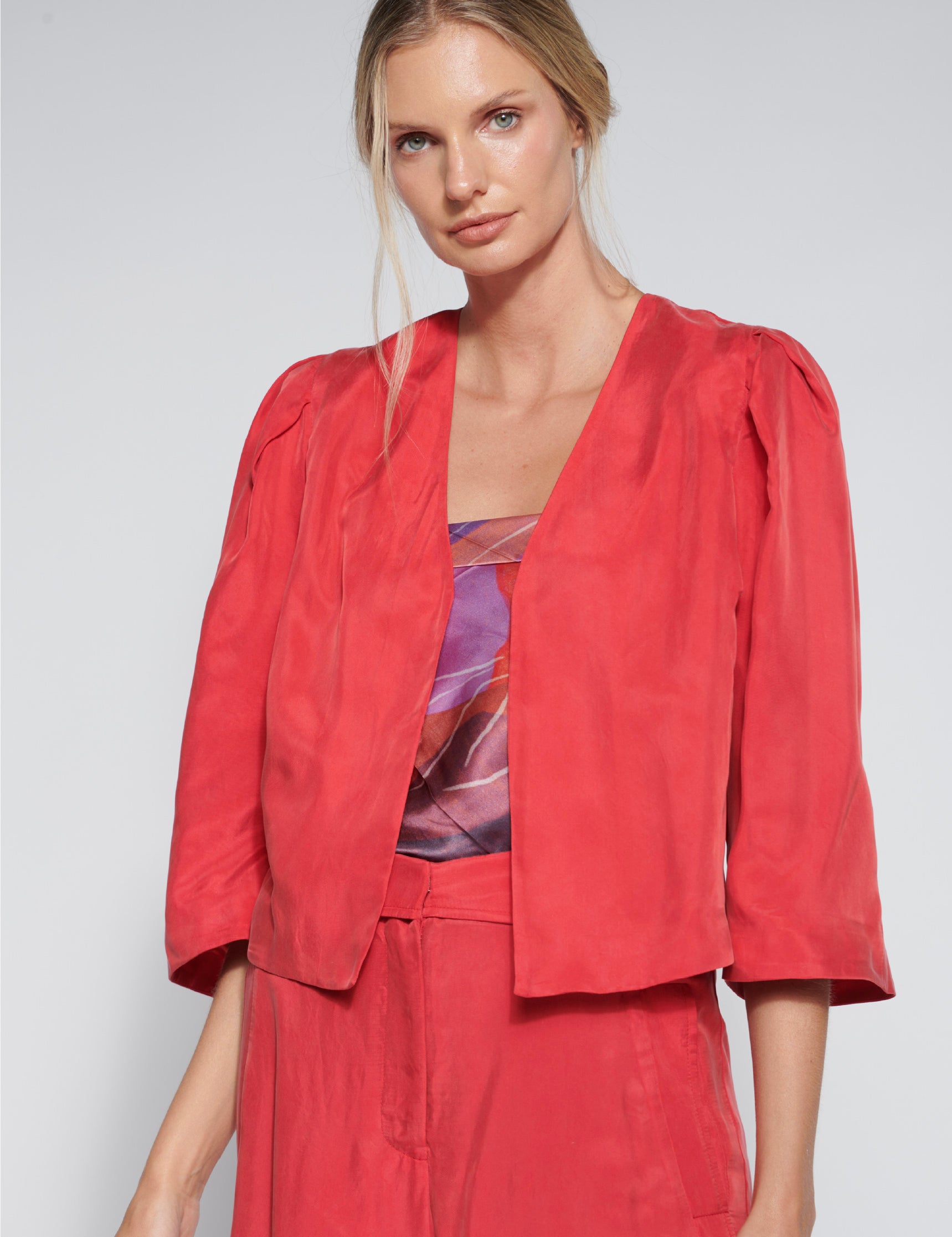 Chaqueta Toral roja de la marca FI-2026-902, abrigo de estilo moderno con cierre y cuello alto, vista frontal.