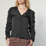 Blusa negra Leticia de la marca EI-2025-610, vista frontal, con detalles suaves y estilo casual.