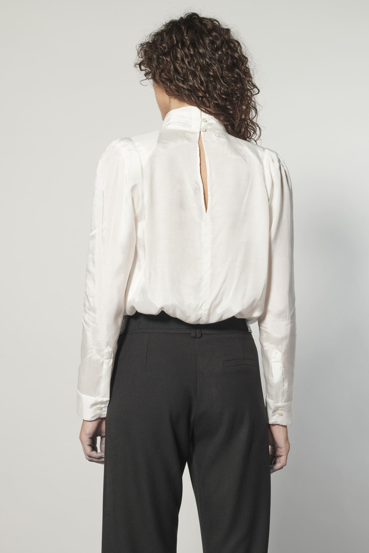Vista trasera blusa Nord blanca con abertura y botones decorativos en la espalda