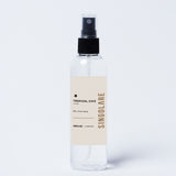 Spray aromático para el hogar Mini Home Spray Tropical Chic de la marca MS-0000-150, envase de 120 ml sobre una mesa decorativa.