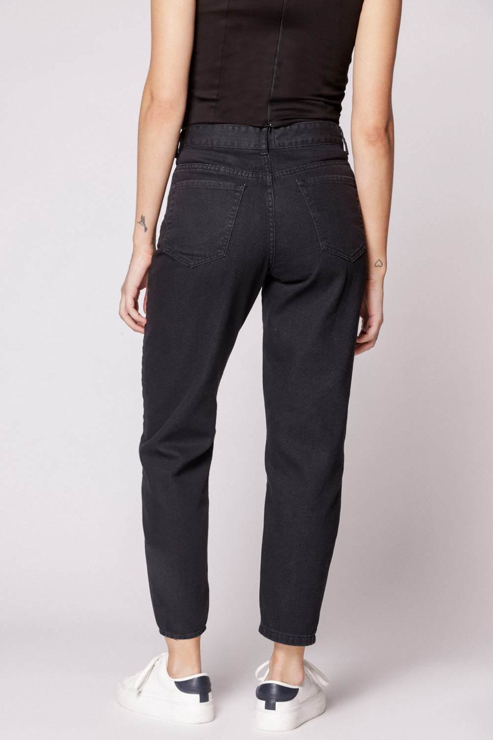 Vista trasera de jeans mom fit negros con bolsillos de parche y tobillo ajustado