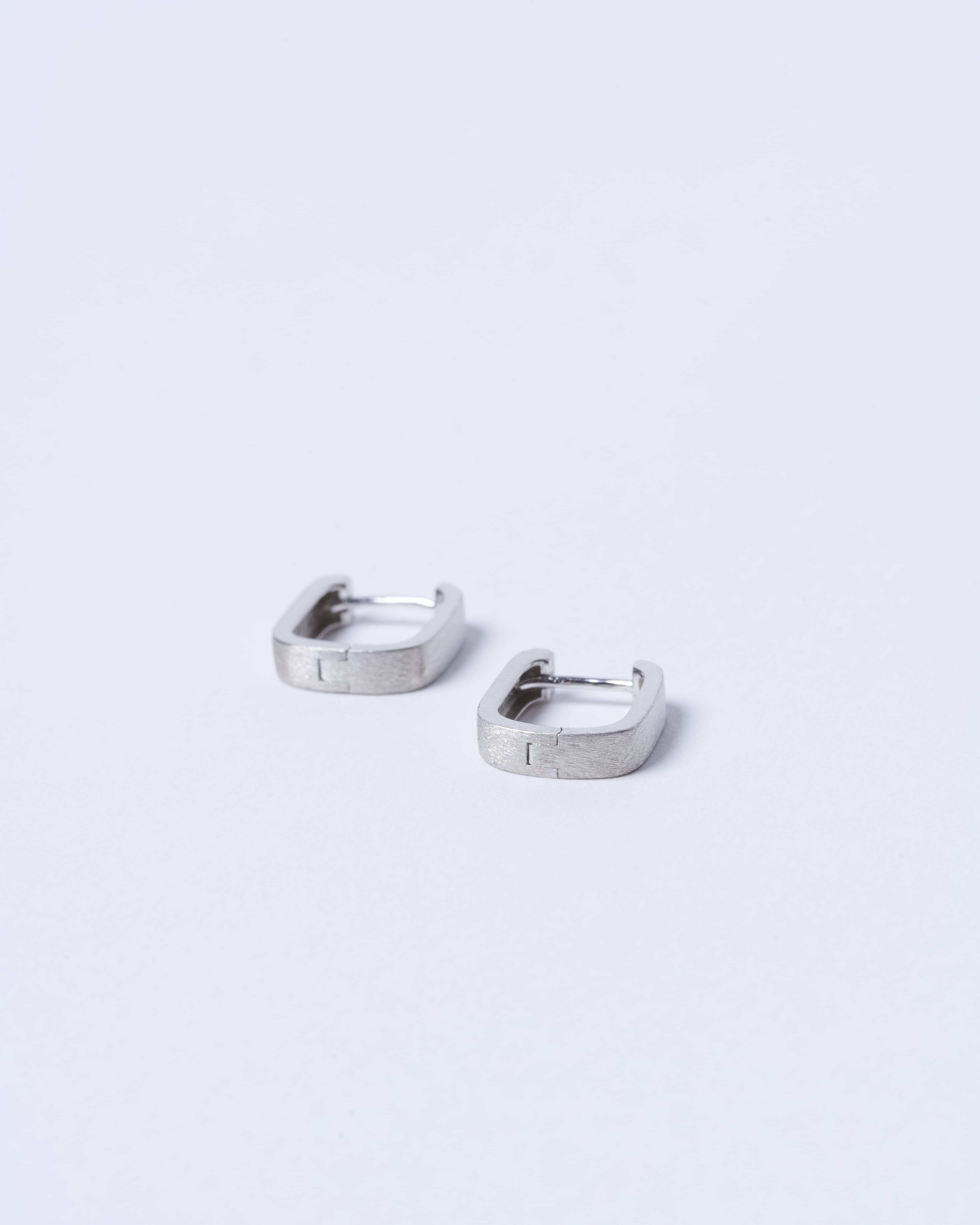 Aros Olave de plata, diseño elegante y moderno, mostrados en primer plano con detalles brillantes y acabado pulido.