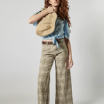 Modelo usando jeans culotte animal print con blusa celeste y bolso tejido, estilo urbano