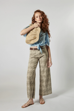 Modelo usando jeans culotte animal print con blusa celeste y bolso tejido, estilo urbano