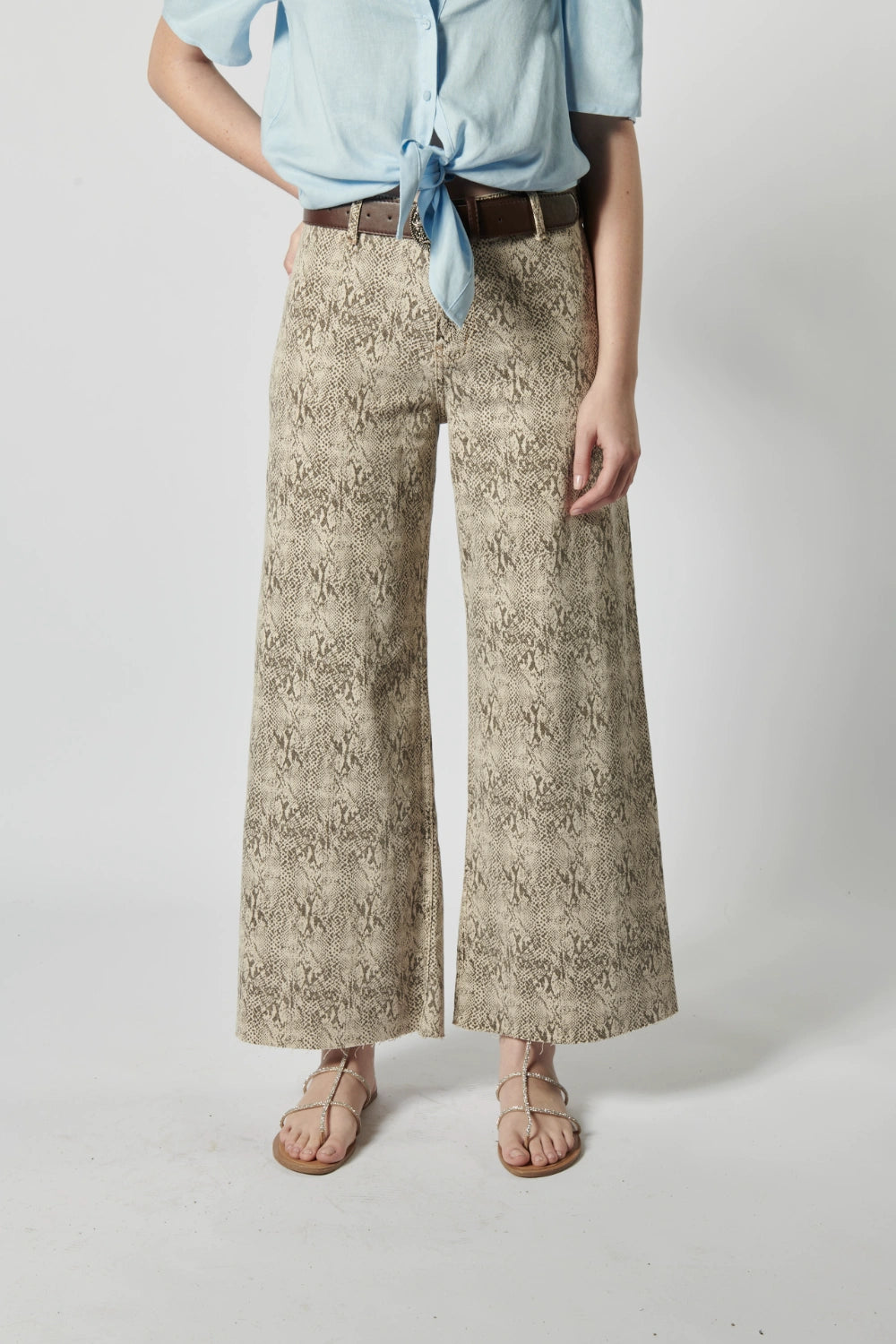 Modelo usando jeans culotte animal print con blusa celeste y bolso tejido, estilo urbano