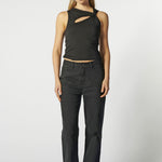 Modelo con jeans flare negro y top negro estructurado, vista frontal
