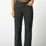 Primer plano frontal de jeans flare negros mujer, tiro alto y calce ajustado en muslos