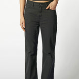 Primer plano frontal de jeans flare negros mujer, tiro alto y calce ajustado en muslos