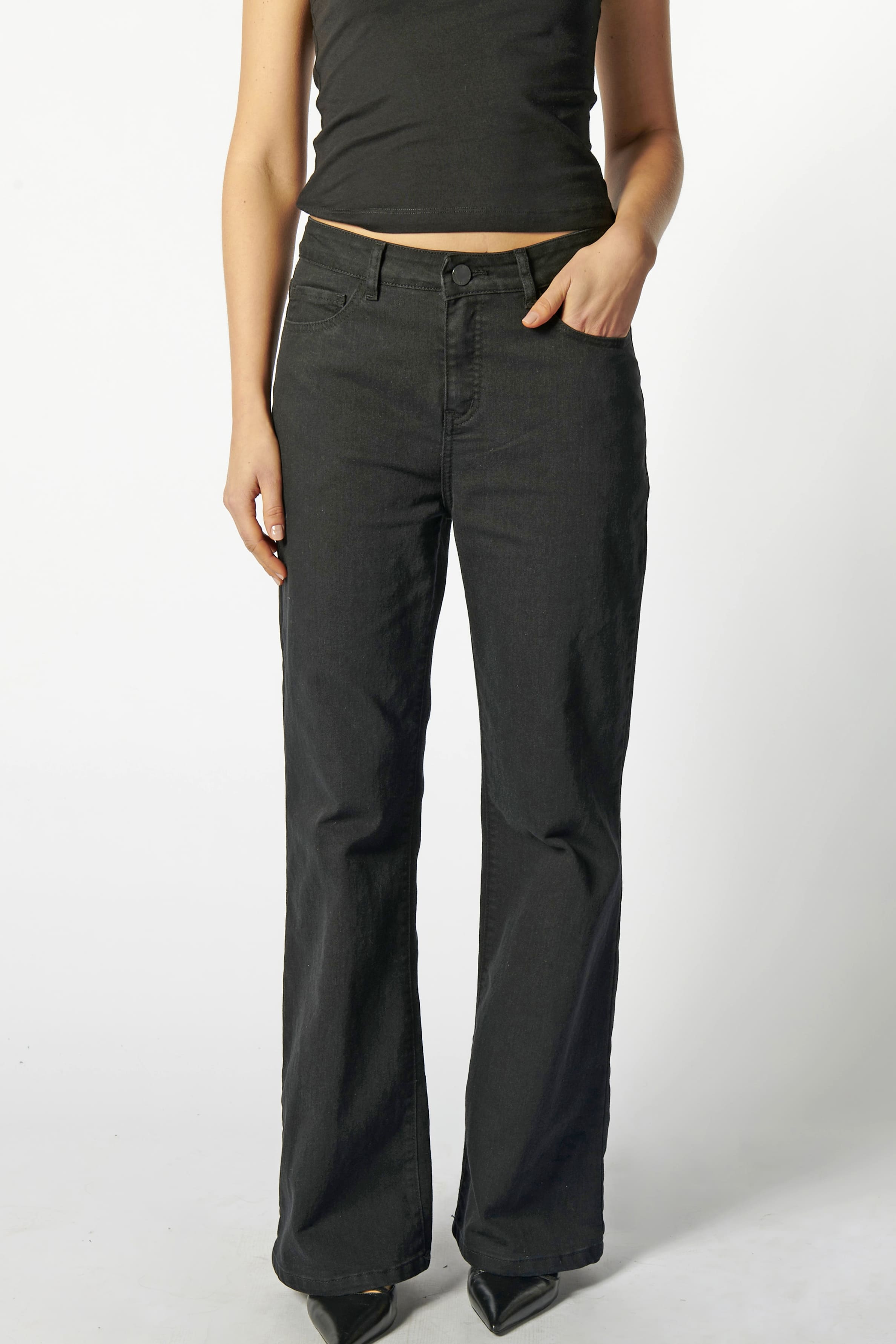 Primer plano frontal de jeans flare negros mujer, tiro alto y calce ajustado en muslos