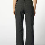 Vista trasera de jeans flare negro con logo minimalista "Singolare" en el bolsillos de parche derecho y costuras en contraste