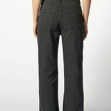 Vista trasera de jeans flare negro con logo minimalista "Singolare" en el bolsillos de parche derecho y costuras en contraste