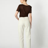 Modelo usando jeans mom fit blancos de espalda