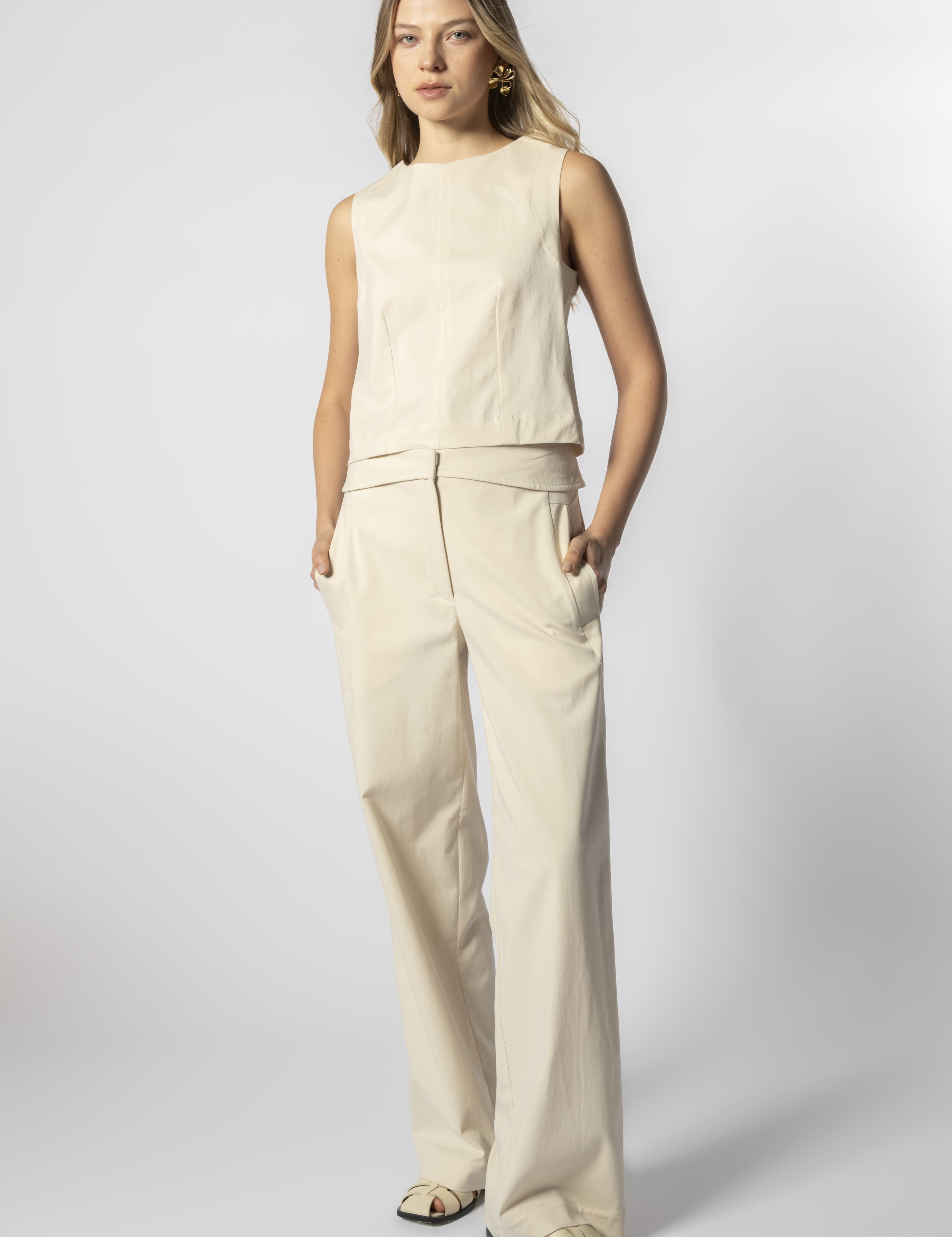 Modelo con pantalón Parla arena y top sin mangas beige, look minimalista