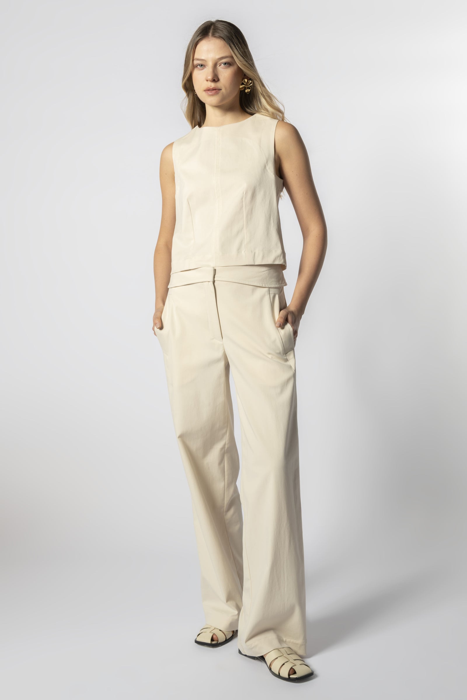 Modelo con pantalón Parla arena y top sin mangas beige, look minimalista