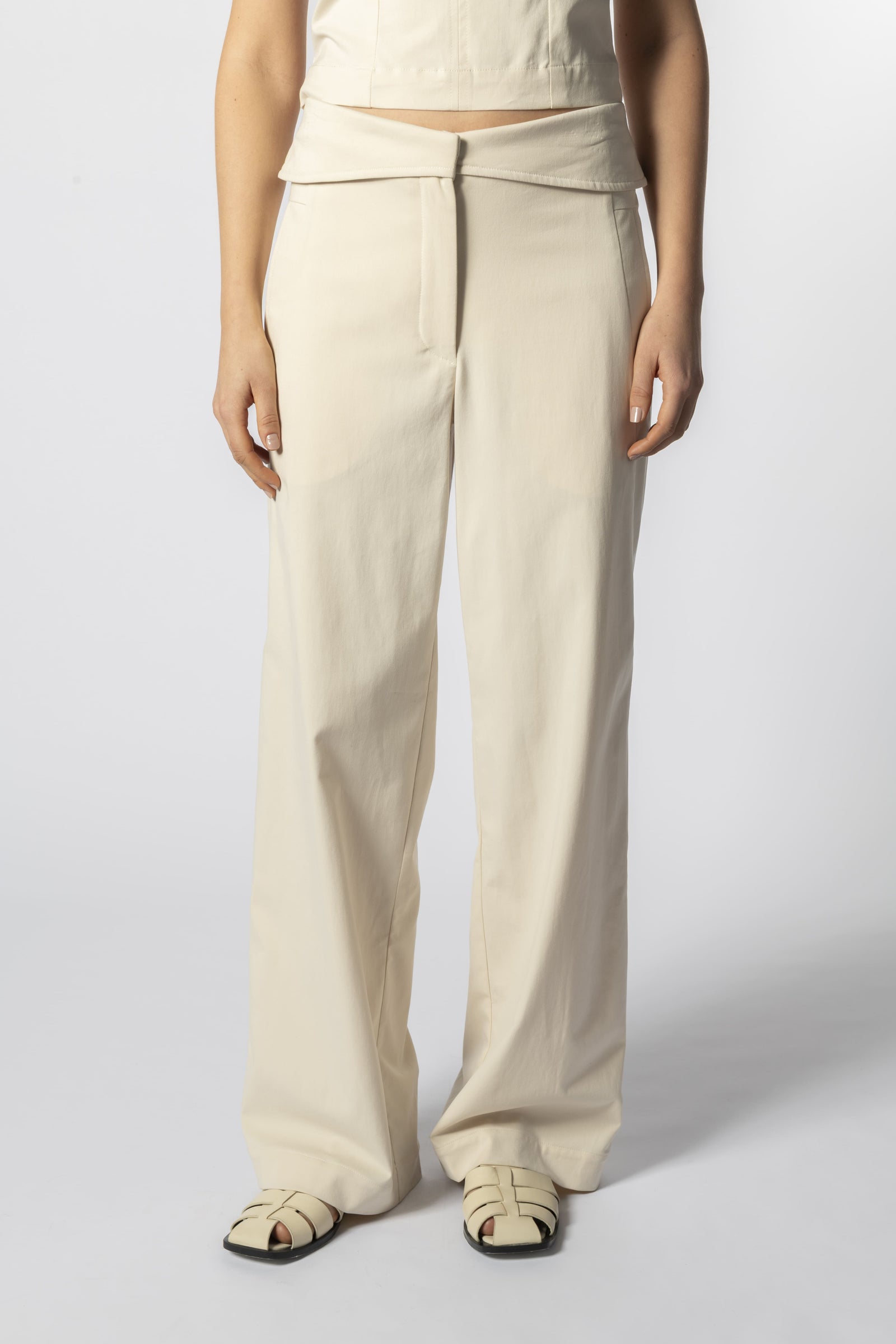 Modelo con pantalón Parla arena y top sin mangas beige, look minimalista