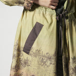 Vestido trench Amiens de la marca V-2026-901, vestido elegante tipo trench en color neutro, con detalles de cinturón y botones.