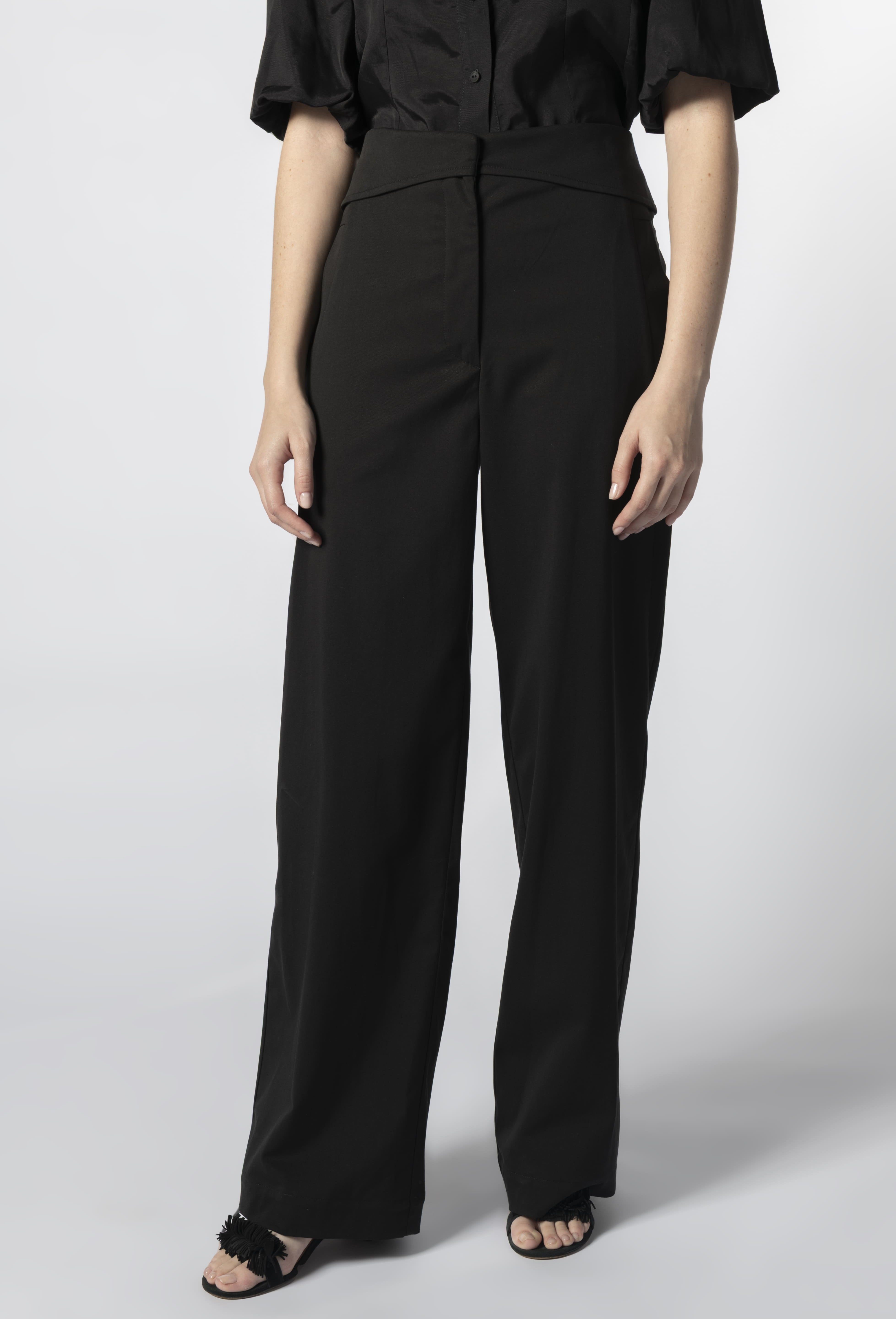Vista frontal en primer plano de pantalón negro mujer estilo sastrero, pierna recta y pretina ancha