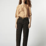 Modelo con jeans barrel color ladrillo oscuro y blusa fluida rosa palo
