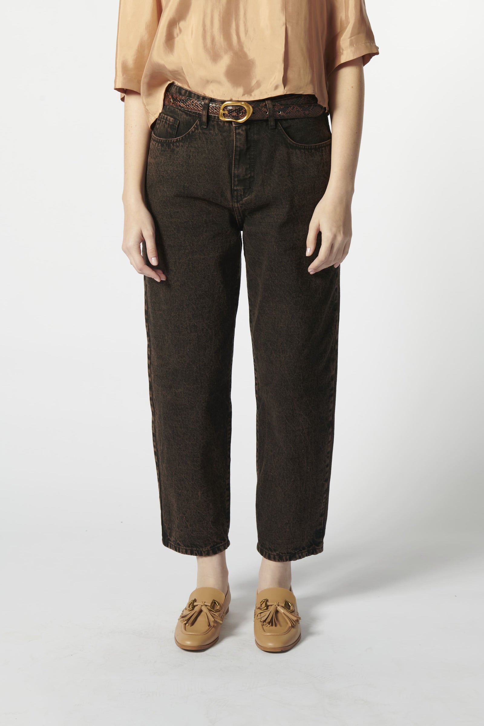 Modelo con jeans barrel color ladrillo oscuro y blusa fluida rosa palo
