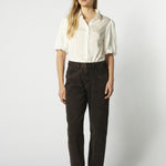 Modelo usando jeans mom fit chocolate con camisa blanca