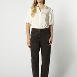 Modelo usando jeans mom fit chocolate con camisa blanca