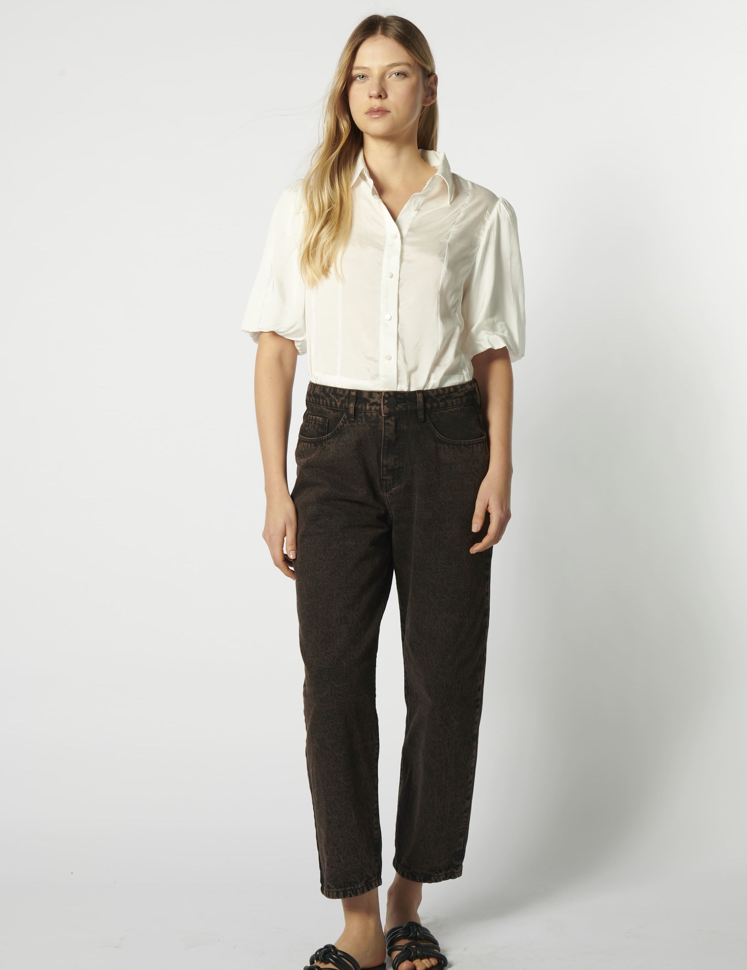 Modelo usando jeans mom fit chocolate con camisa blanca