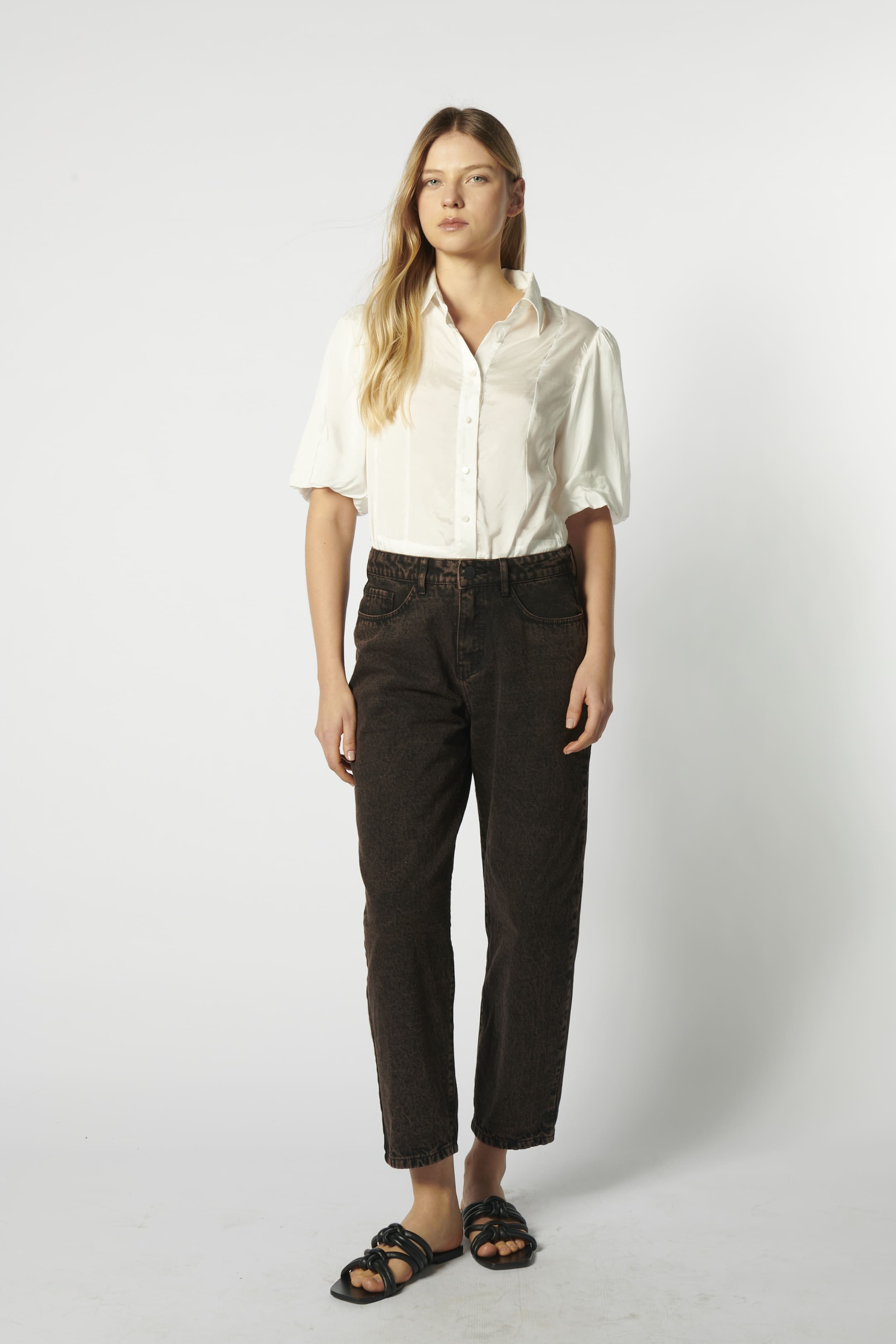 Modelo usando jeans mom fit chocolate con camisa blanca