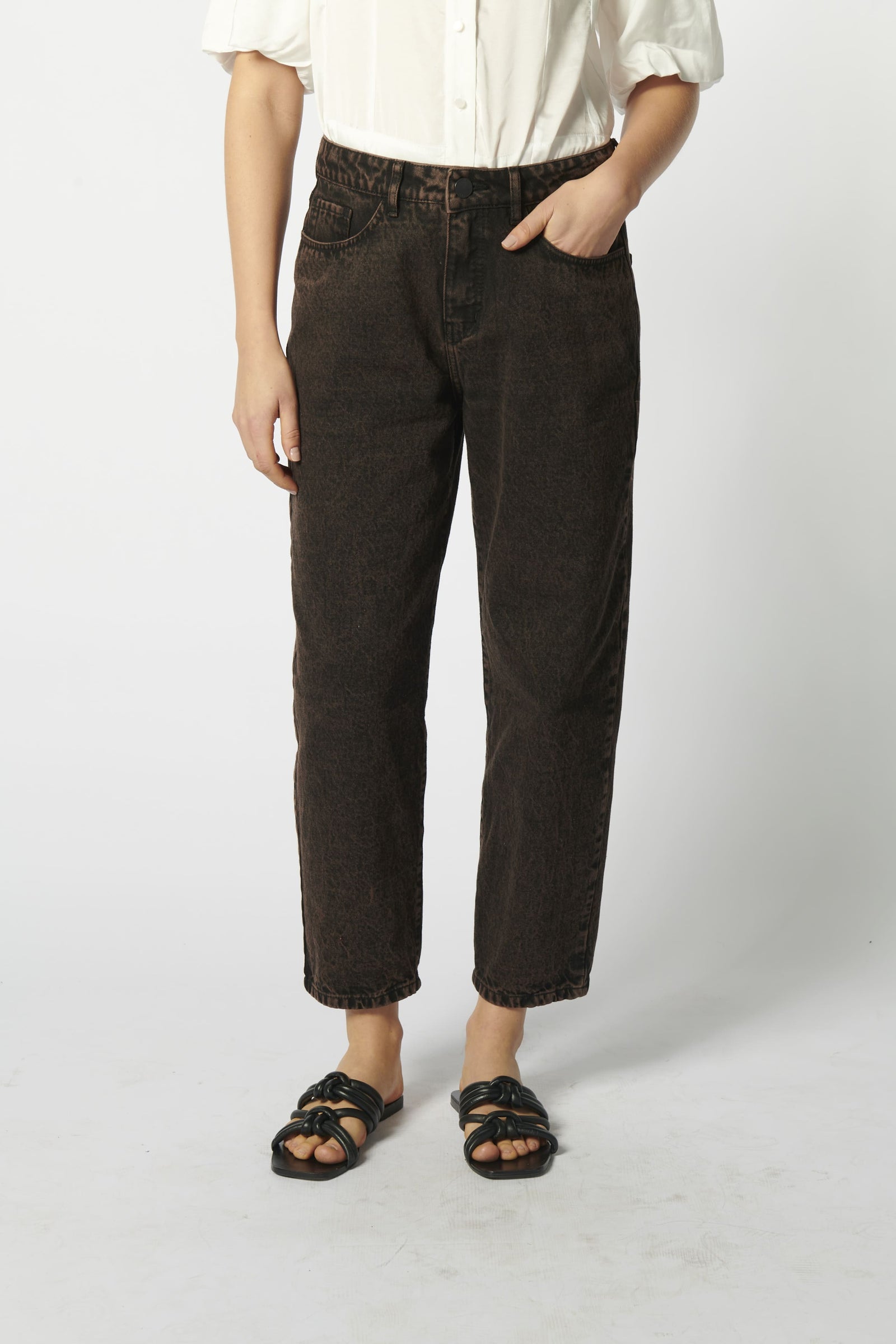 Modelo usando jeans mom fit chocolate con camisa blanca