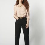 Modelo usando jeans barrel mujer color negro con blusa rosa y cinturón