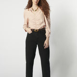 Modelo usando jeans barrel mujer color negro con blusa rosa y cinturón