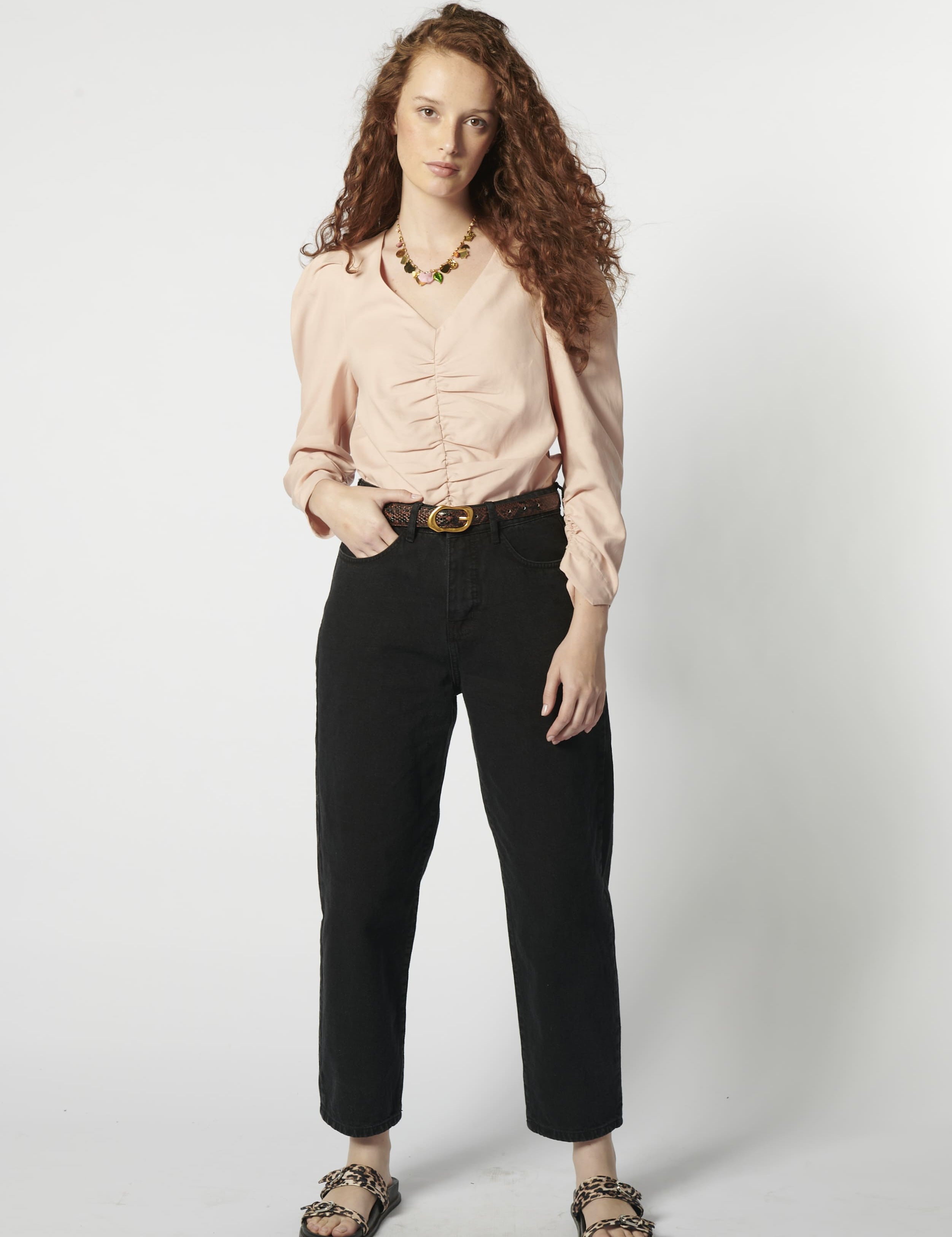 Modelo usando jeans barrel mujer color negro con blusa rosa y cinturón