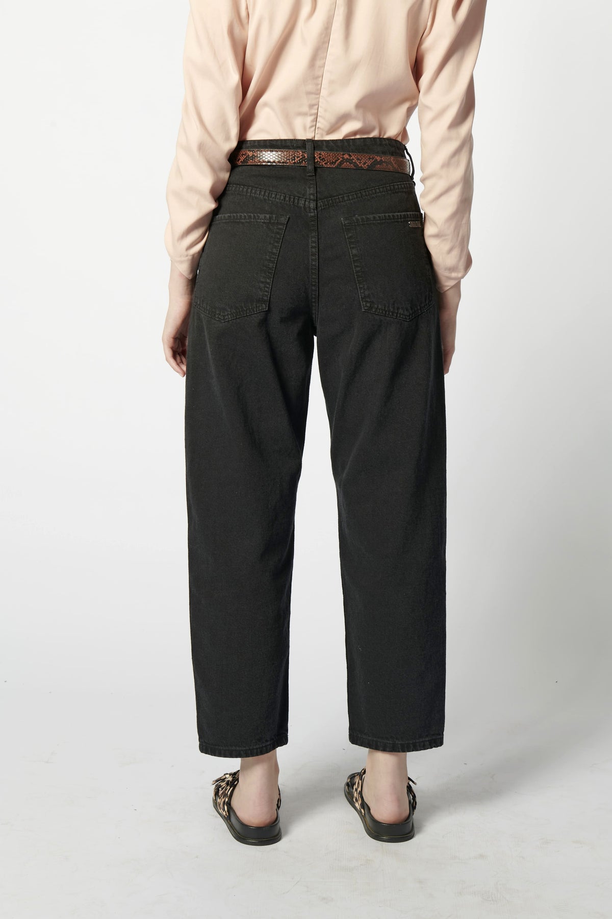 Vista trasera de jeans barrel color negro en look casual urbano.