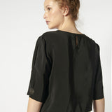 Blusa Tou Nemi de color blanco y diseño simple, mostrada en la imagen con detalles suaves y estilo elegante.