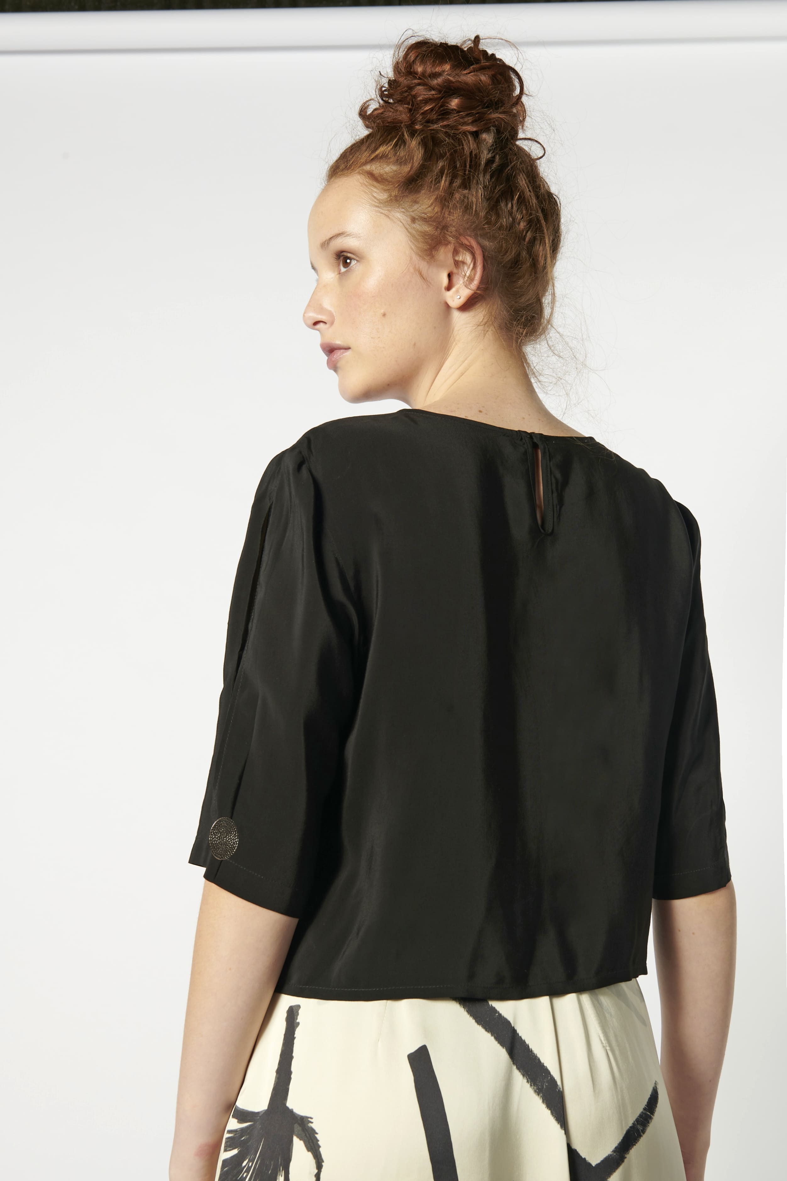 Blusa Tou Nemi de color blanco y diseño simple, mostrada en la imagen con detalles suaves y estilo elegante.