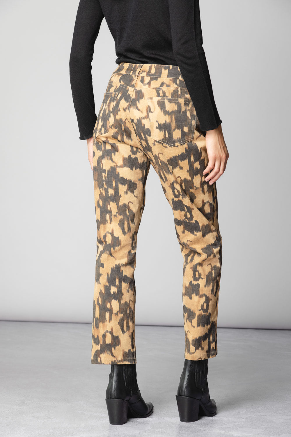 Pantalón Tamia de la marca O-2025-802 en color oscuro, con diseño ajustado y bolsillos, mostrado en la imagen.