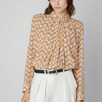 Blusa Maine de la marca O-2025-600, con diseño elegante y detalles en la parte superior, en tonos neutros.