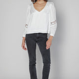 Blusa Marie de la marca O-2025-606, blusa de tela ligera en color neutro, con diseño elegante y detalles en las mangas.