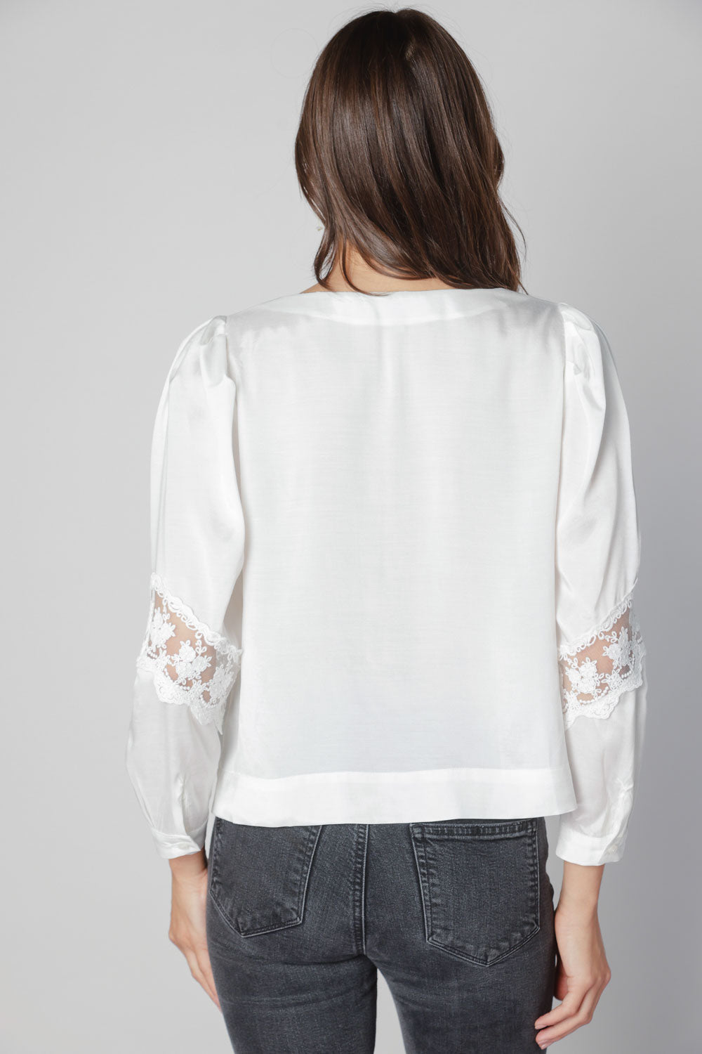 Blusa Marie de la marca O-2025-606 en color blanco, con diseño elegante y mangas largas, para un estilo sofisticado.